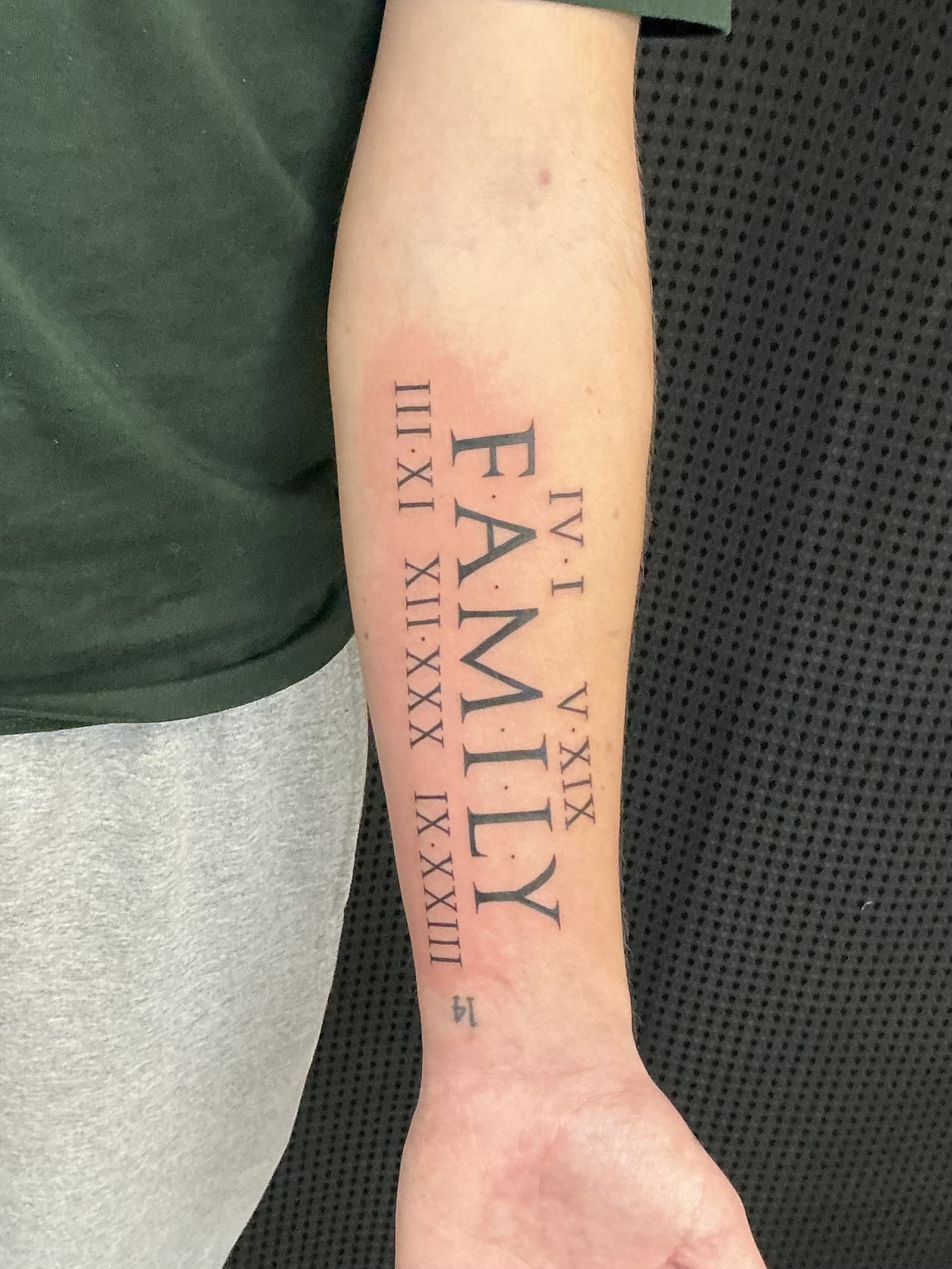 Family forearm tattoo with Roman numerals