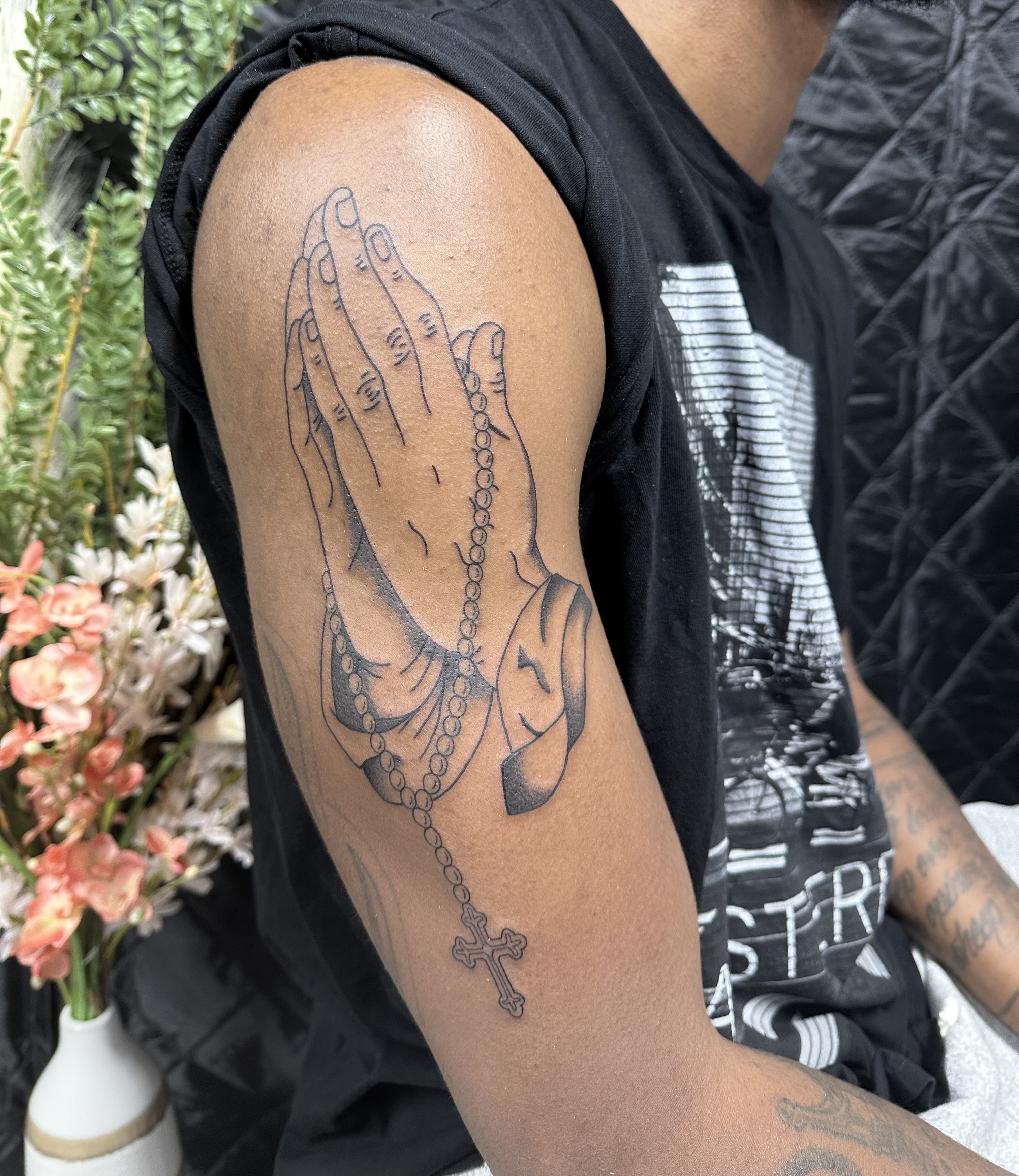 Praying hands upper arm tattoo